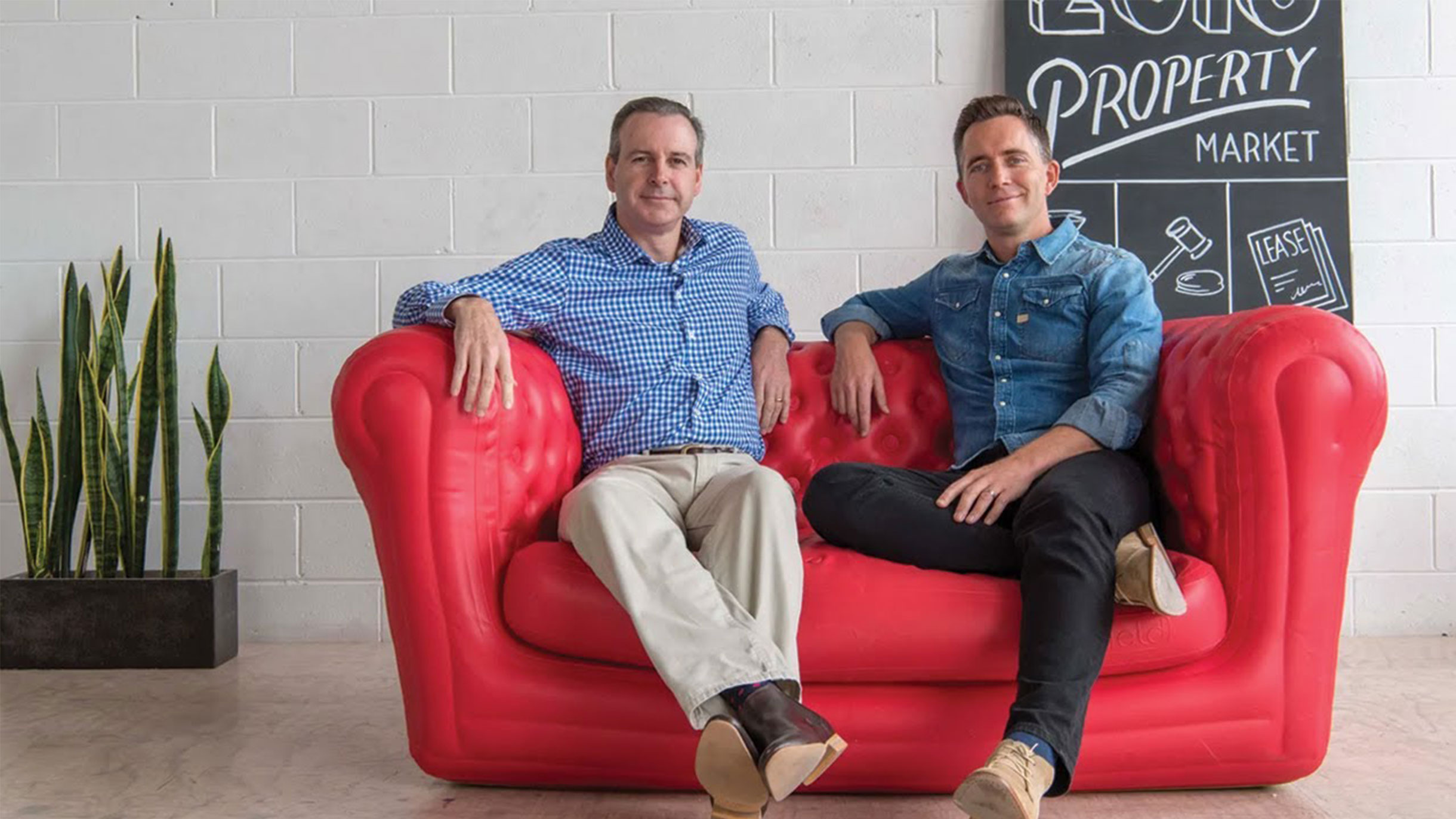 Hosts of the Property Couch Bryce Holdaway and Ben Kingsley sit on an inflatable red couch